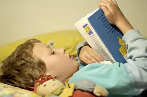 Boy Reading In Bed Stampe: Boy reading in bed