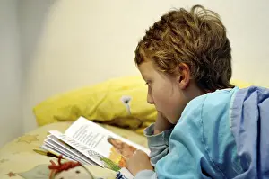 Boy Reading In Bed Stampe: Boy reading in bed