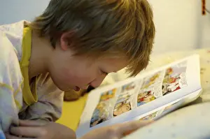 Boy Reading In Bed Stampe: Boy reading in bed
