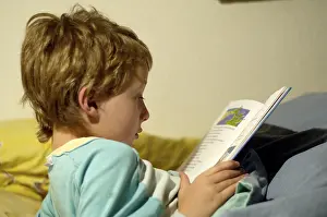Boy Reading In Bed Stampe: Boy reading in bed