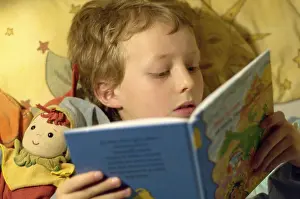 Education For Kids Stampe: Boy reading in bed