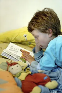 Boy Reading In Bed Stampe: Boy reading in bed