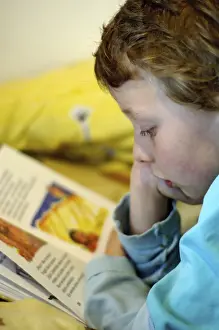 Boy Reading In Bed Stampe: Boy reading in bed