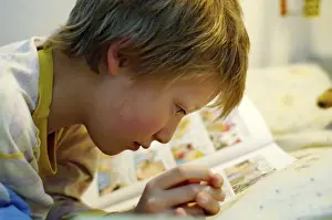 Boy Reading In Bed Stampe: Boy reading in bed