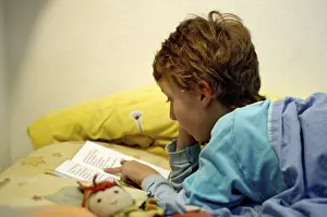 Boy Reading In Bed Stampe: Boy reading in bed