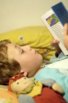 Boy Reading In Bed Stampe: Boy reading in bed