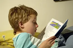Boy Reading In Bed Stampe: Boy reading in bed