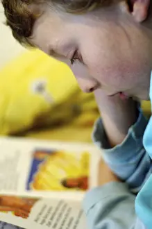 Boy Reading In Bed Stampe: Boy reading in bed