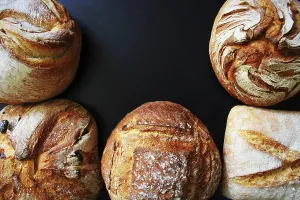 Bakery Products Stampe: Bread. Assortment of different types of bread on a blackn background
