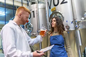 Industrial Building Architecture Stampe: Brewery workers evaluating beer sample for quality control