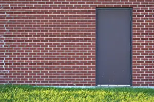 Ontario Canada Landscape Photography Stampe: Brick wall with rectangular door and a meadow in front of it