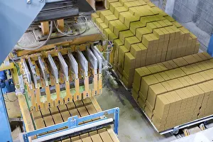 Industrial Building Interior Stampe: Brickyard. Top view of machine and stacked bricks in workshop