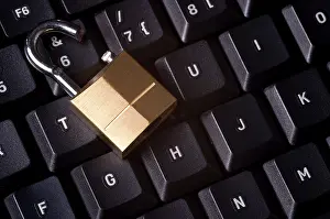 Computer Security Breach Stampe: A broken padlock on top a computer keyboard to represent the concept of computer security breach