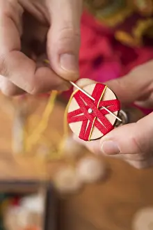 Traditional Crafting Techniques Stampe: Button maker stitching and wrapping red and yellow yarn into star pattern