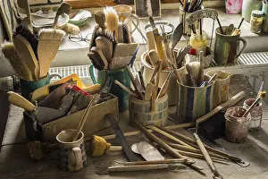 Ceramic Workshop Germany Stampe: Ceramic workshop, tools and brushes in pots on workbench