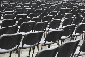 Empty Chair Rows Stampe: Chairs covered with gray plastic stand in rows in a function room