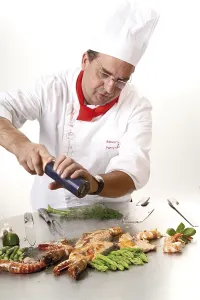 Gambero Reale Stampe: Il cuoco aggiunge pepe a un griglia teppan.