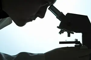 Indoor Studio Photography Stampe: Chemist looking through a microscope