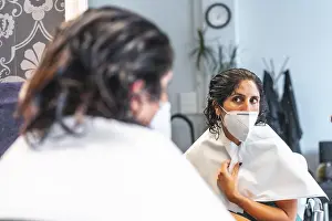 COVID 19 Safety Measures Stampe: Client with face mask looking in the mirror