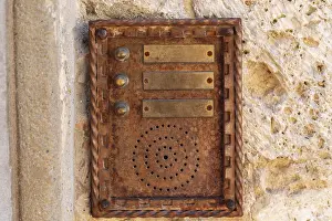 Traditional Building Design Stampe: Close up of an old rusty intercom embedded in weathered stone wall