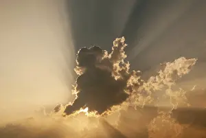Cloudy Atmosphere Photography Stampe: Cloud in front of the sun showing rays of light