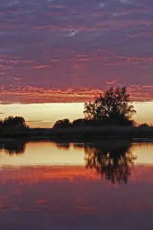 German Nature Park Scenery Stampe: Clouds in the sunset with reflection on the river Trebel