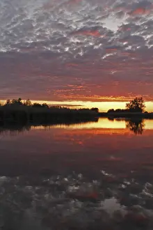 Northern Germany Nature Reserve Scenery Stampe: Clouds in the sunset with reflection on the river Trebel