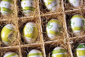 Christian Easter Traditions Stampe: Coloured Easter eggs in a box with straw