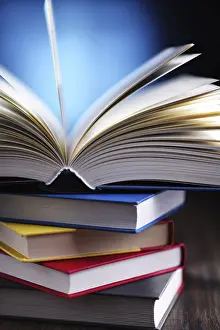 University College Study Space Stampe: A composition with an open book lying on a stack of other books