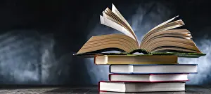 Educational Institution Stampe: A composition with an open book lying on a stack of other books