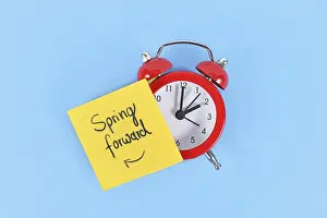 Daylight Saving Time Concept Stampe: Concept for summer daylight saving time with clock and note saying Spring forward