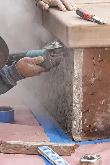 Manpower In Construction Stampe: Construction worker using grinder at construction site