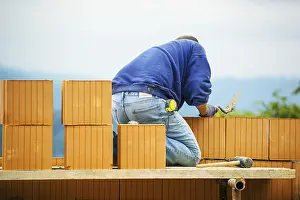Construction Worker Stampe: Construction workers erecting a brick shell