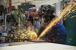 Workplace Safety Equipment Stampe: Craftsmen working with an angle grinder in his workshop