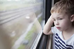 Boy Looking Out Window Stampe: Curious boy looking out the window of a speeding train