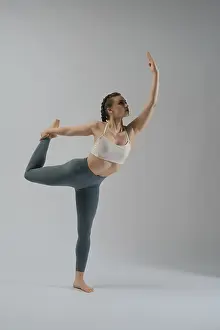 Elegant Movement Stampe: A dancer showcases her flexibility and strength while executing an elegant pose in a studio