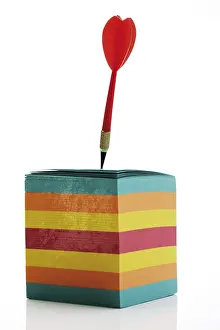Colourful Office Supply Stampe: Dart stuck in a stack of multicoloured notepaper