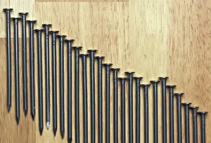 Close Up Construction Tools Stampe: Declining Graph of Nails on a Wood Background