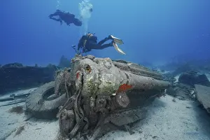 Underwater Wreck Exploration Stampe: Two divers explore the engine of a large wreck on the seabed