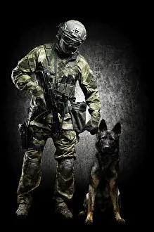 German Shepherd Breed Stampe: Dog handler posing in the studio with a trained shepherd