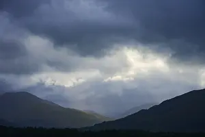 Dramatic Mountain Landscape Stampe: Dramatic mountain landscape under cloudy sky with rays of light