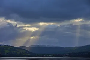 Northern Europe Waterfront Scene Stampe: Dramatic rays of light through a cloudy landscape over a lake