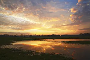 Atmospheric Evening Atmosphere Stampe: Dramatic sky at sunset with reflection in flooded meadow