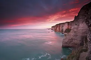 Rocky Coastline Scenery Stampe: Dramatic sunrise over ocean and cliffs