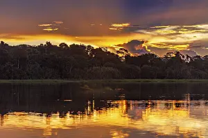 Dramatic Cloudy Skies Stampe: Dramatic sunset with clouds over a river in the Amazon