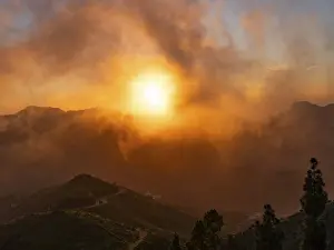 Dramatic Mountain Landscape Stampe: Dramatic sunset lighting up the clouds and mist over the mountains