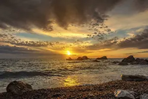 Atmospheric Landscape Photography Stampe: Dramatic sunset sky over beach rocks and waves