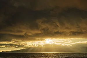 Soft Lightning In The Evening Sky Stampe: Dramatic sunset with sun rays breaking through the clouds over the sea