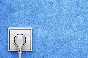 Power Supply Socket Stampe: Electrical plug connected into the socket on blue wall