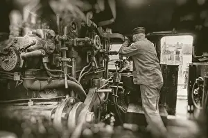 Deserted Railway Station Stampe: Engine driver working on steam train engine